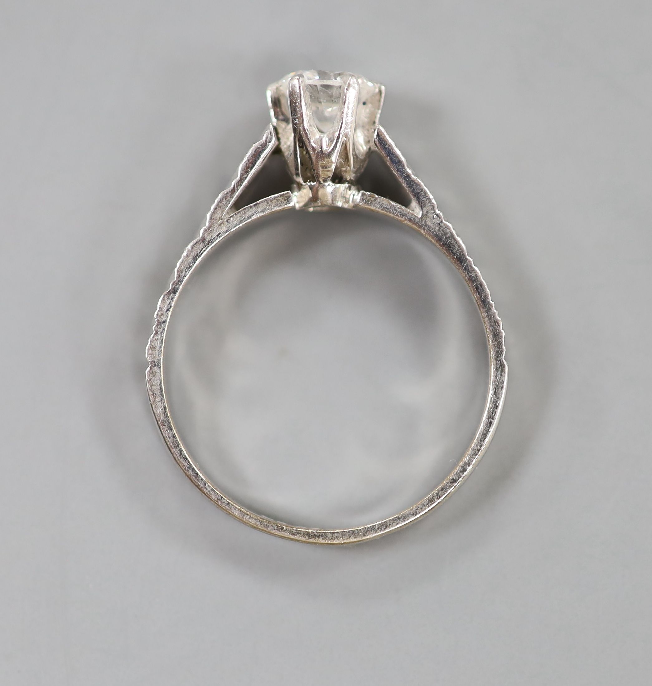 A modern 18ct white metal and solitaire diamond ring, with engraved shoulders